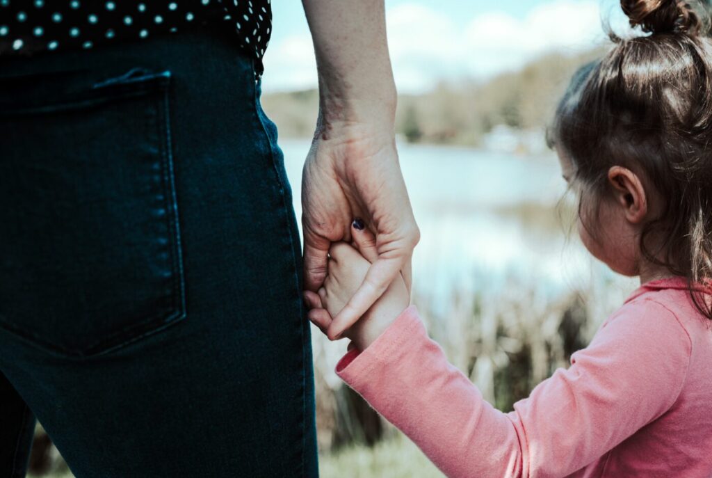 Adult and child holding hands