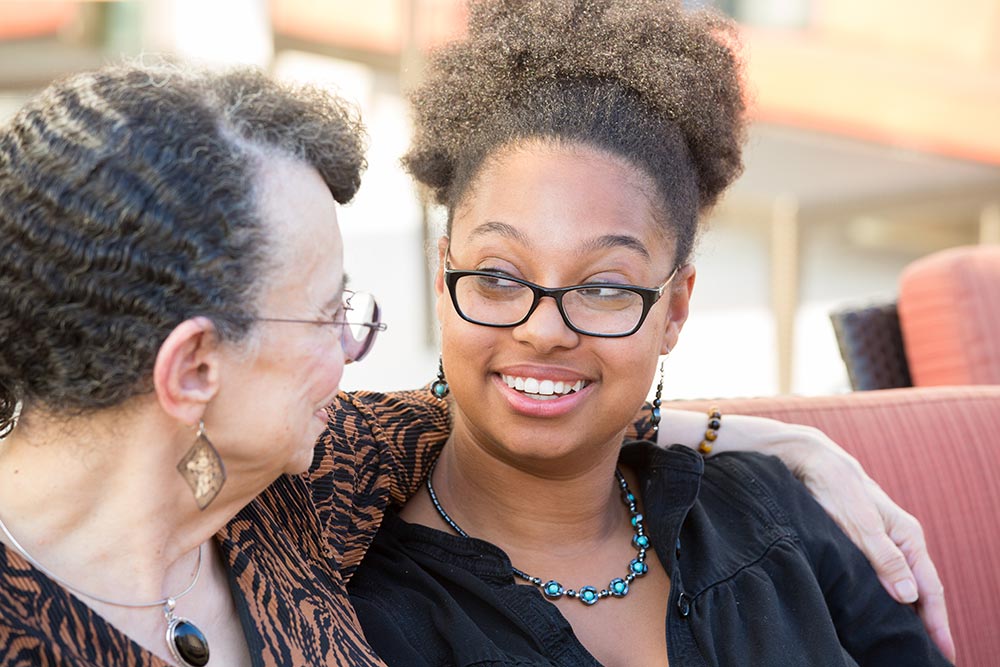 Older and younger adults sitting close and smiling at each other