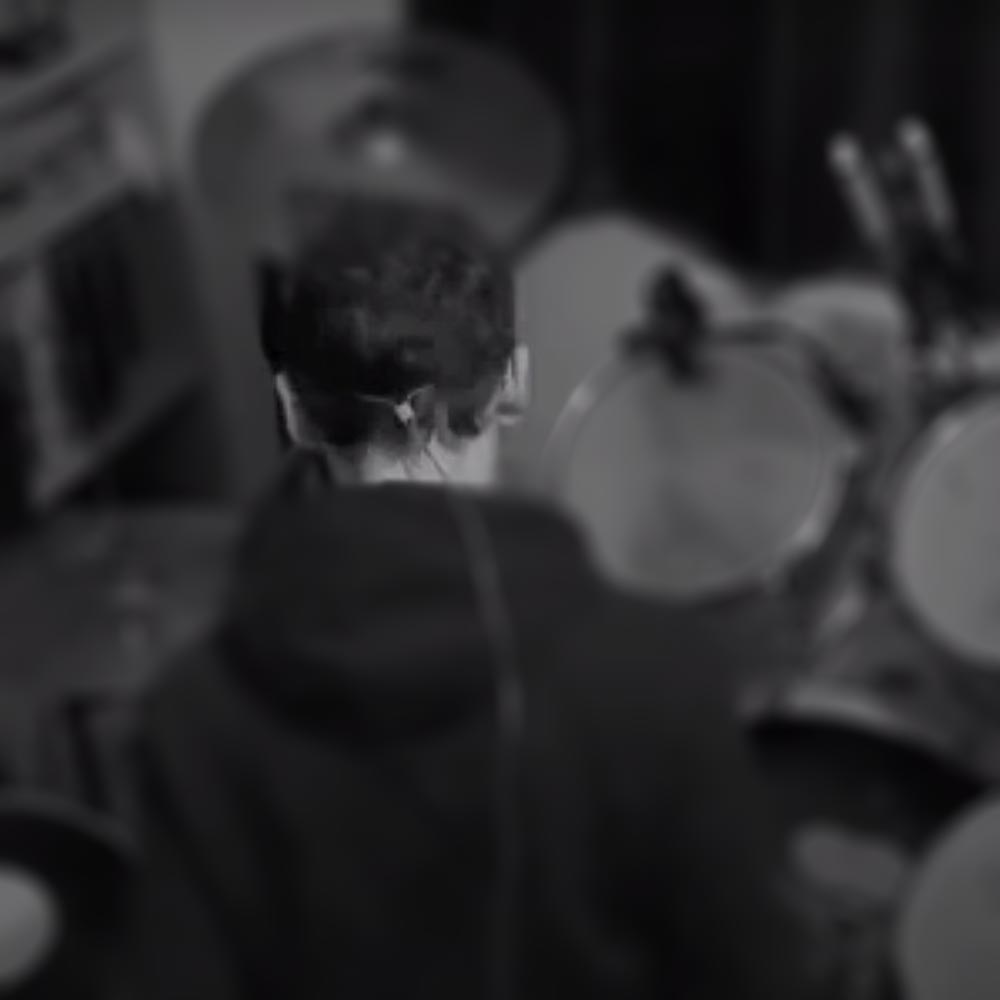 Black and white image of person and drum kit