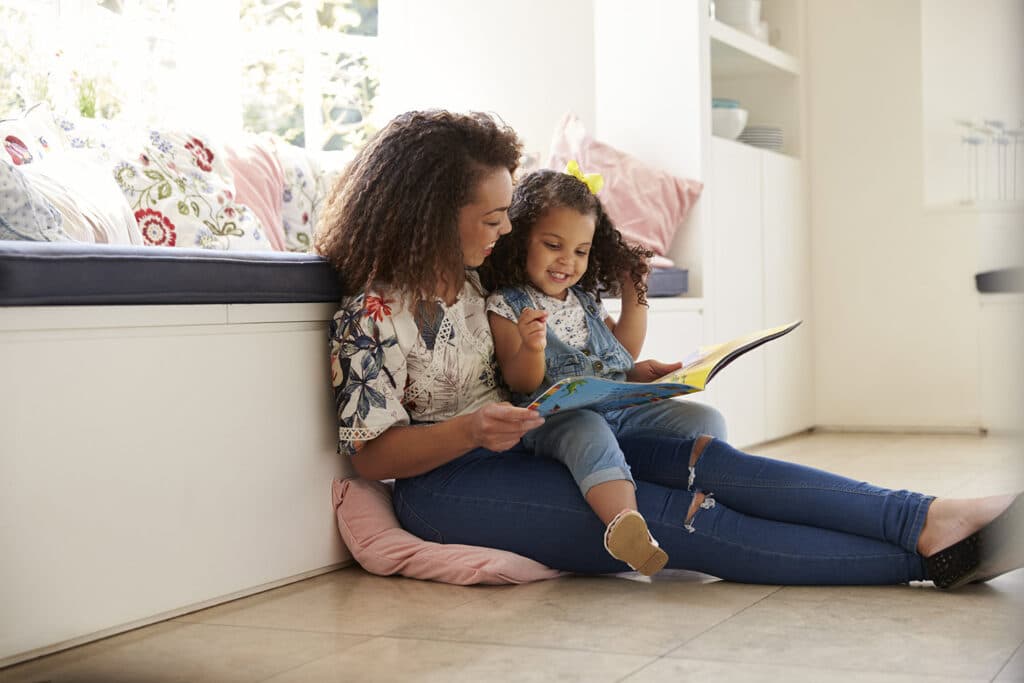 Woman reading book with child